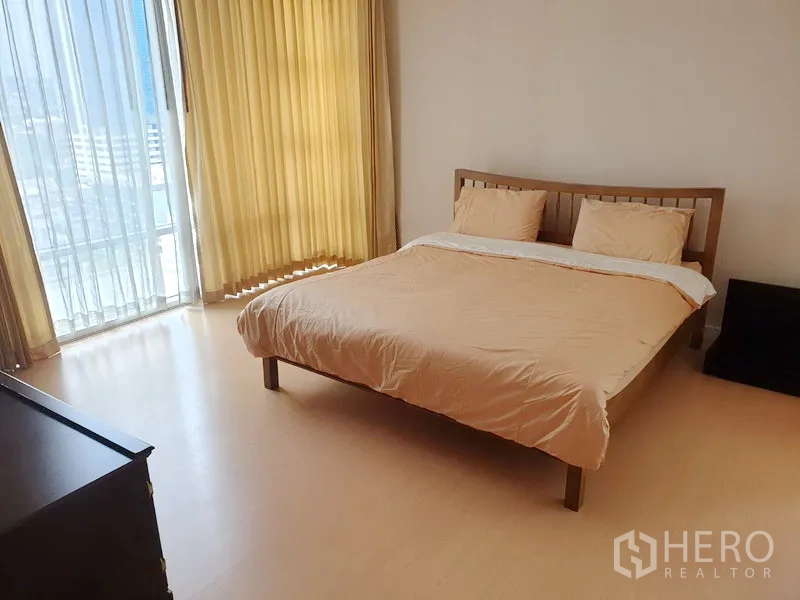 Condominium for rent or sale in Watthana, Bangkok - Master bedroom with large window, light curtains, double bed and skyline outlook.