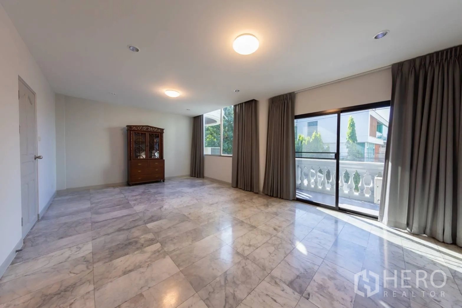 Home Office for rent in Bang Rak, Bangkok - Living room with marble floors opening to a balcony and abundant natural light.