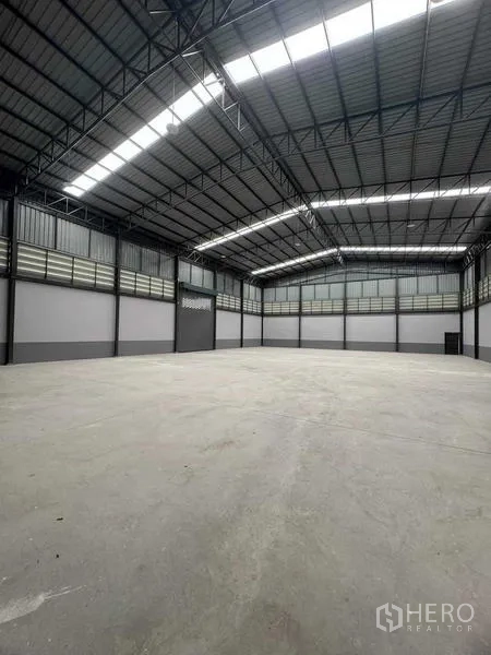 โรงงาน ขายในSamut Sakhon - ภายในโกดังเพดานสูง โครงเหล็ก ช่องแสง และพื้นคอนกรีตเรียบ