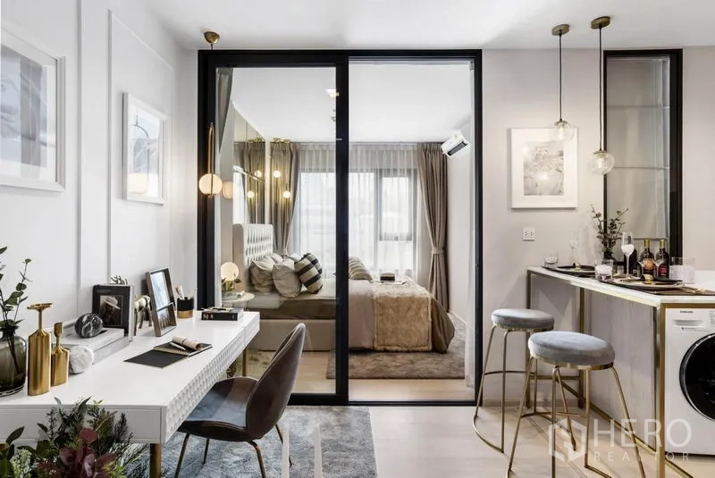 Condominium for sale in Pathum Wan, Bangkok - Open-plan work corner and pantry facing glass doors to the bedroom with pendant lights.
