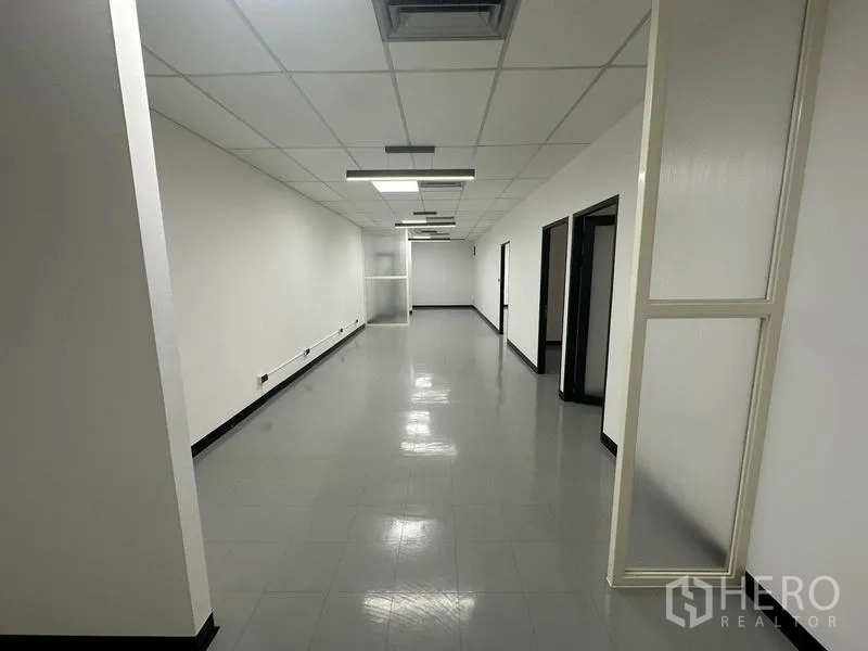 Office Space for rent - Hallway-style office area with multiple doors, grey tiles and suspended ceiling.