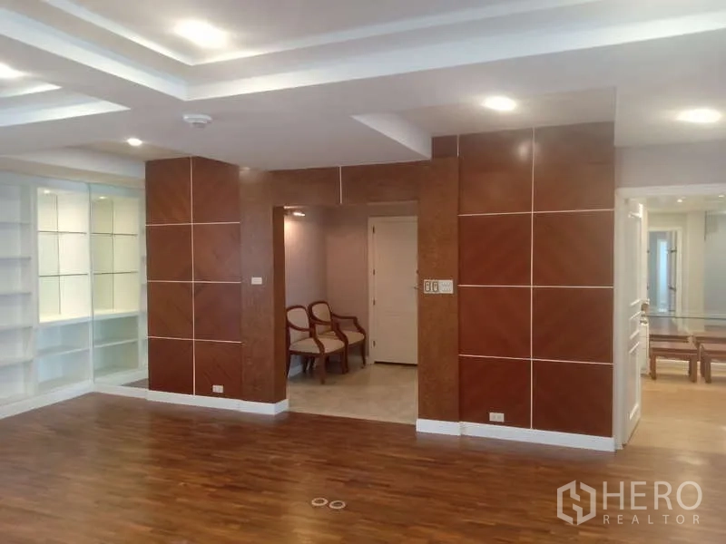 Condominium for rent in Khlong Toei, Bangkok - Foyer with wood panel accents, downlights and illuminated display shelving.