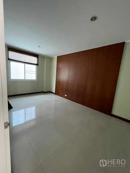 带办公室的家 出租或出售在Min Buri, Bangkok - 明亮空房，亮面地砖、木质强调墙与带百叶的窗户。