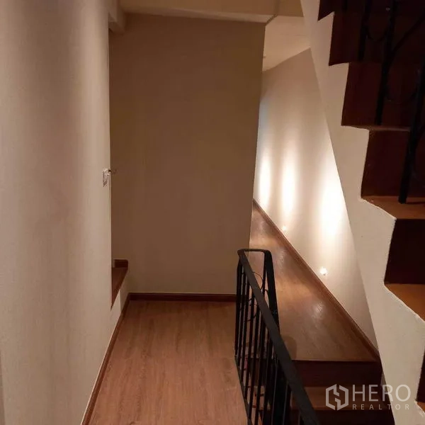 Shophouse for rent in Watthana, Bangkok - Stair landing with metal handrail and accent wall lighting