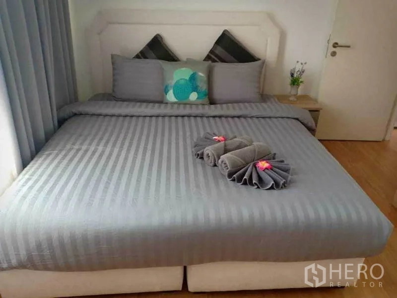 คอนโด ให้เช่าในWatthana, Bangkok - ห้องนอนมาสเตอร์ เตียงคิงไซซ์ ชุดผ้าปูสีเทาและผ้าเช็ดตัวพับ