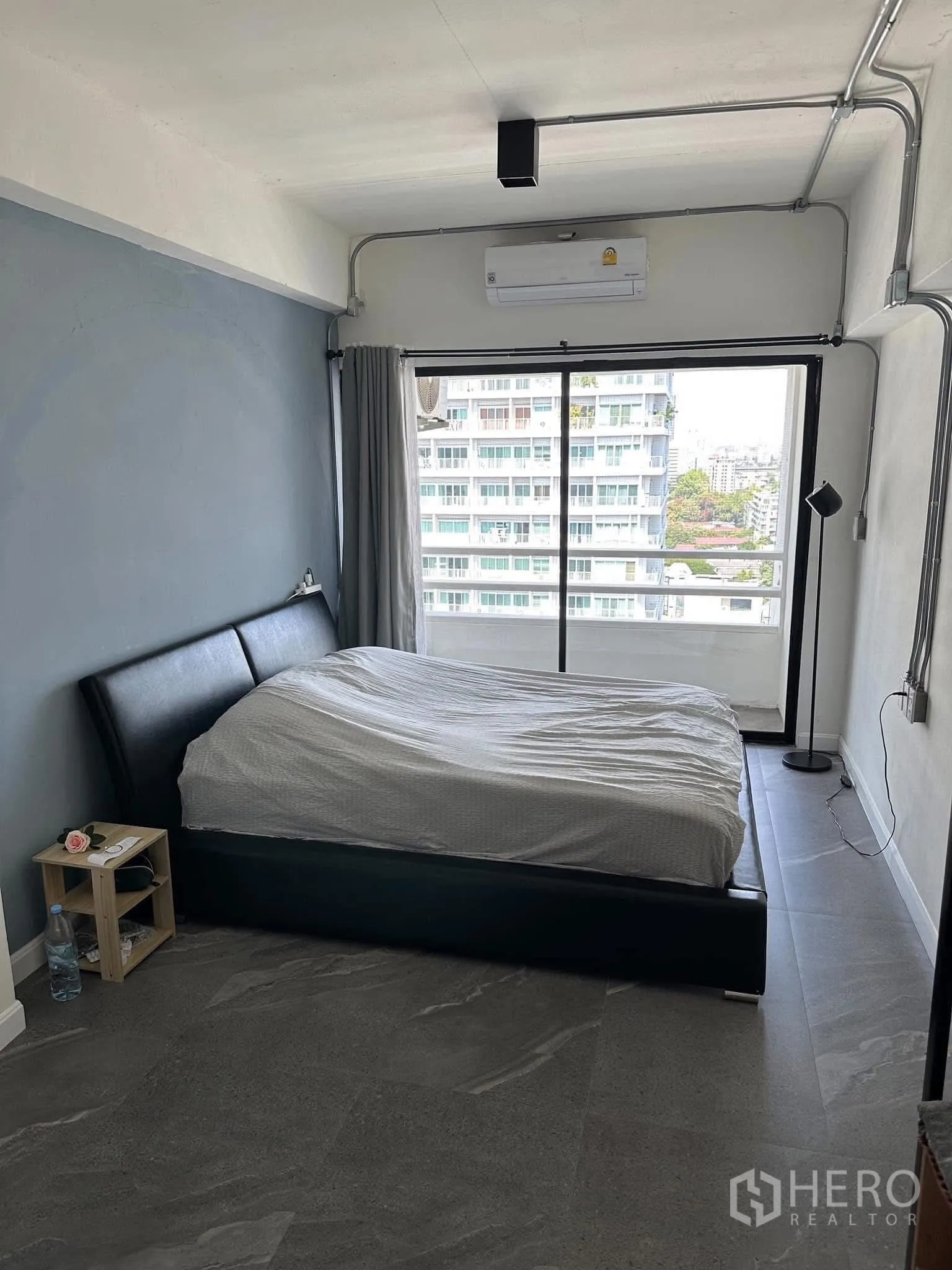 公寓 出租在Watthana, Bangkok - 主卧带双人床，推拉门通向阳台，视野开阔。