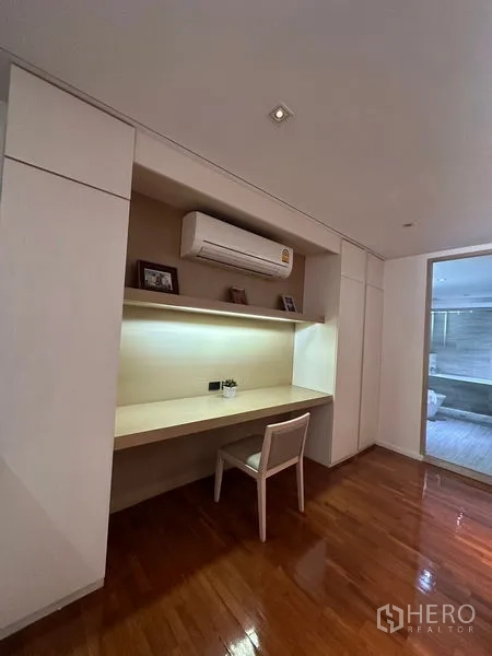 Apartment for rent in Khlong Toei, Bangkok - Built-in study nook with backlit desk, shelves, and air-conditioning.