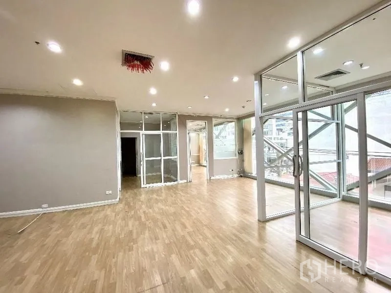 Office Space for rent in Khlong Toei, Bangkok - Modern office interior with sliding glass doors, ceiling downlights and floor-to-ceiling windows.
