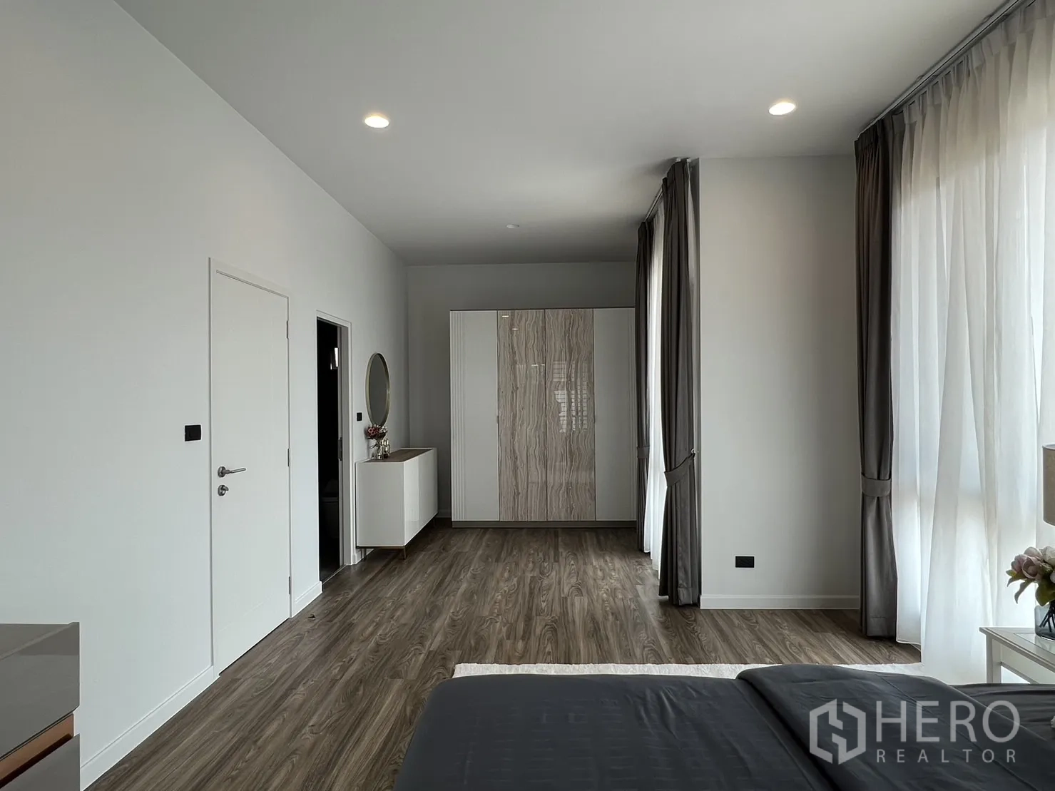 Detached House for rent in Bang Kapi, Bangkok - Master bedroom showing spacious layout with wardrobes and curtains.