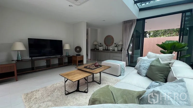 独立式住宅 出租在Lat Krabang, Bangkok - 温馨电视角，大屏电视、矮柜与转角沙发。