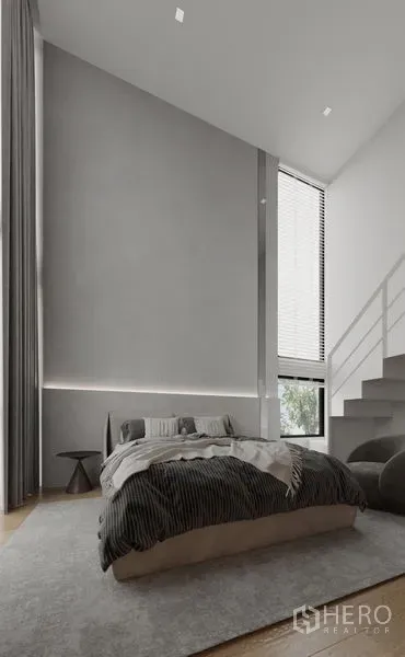 Detached House for rent in Saphan Sung, Bangkok - Double‑height bedroom with tall window, soft gray walls and stairs to a loft.