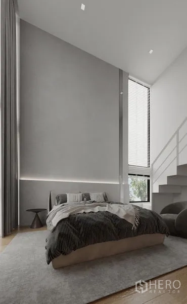 Detached House for rent in Saphan Sung, Bangkok - Double‑height bedroom with tall window, soft gray walls and stairs to a loft.
