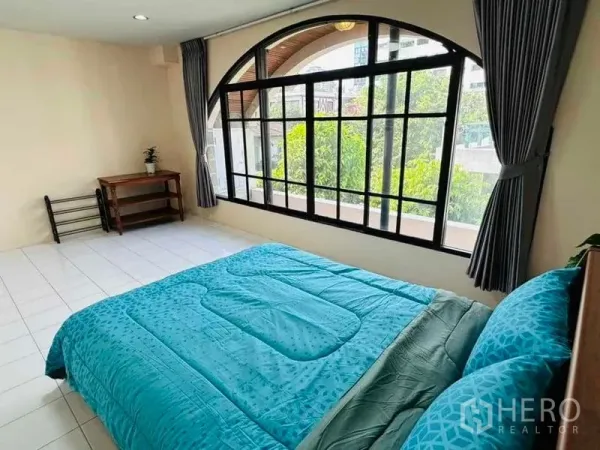 สำนักงานที่บ้าน ให้เช่า - ห้องนอนหน้าต่างโค้งบานใหญ่เห็นวิวต้นไม้ ชุดเครื่องนอนสีฟ้าเทอร์ควอยส์