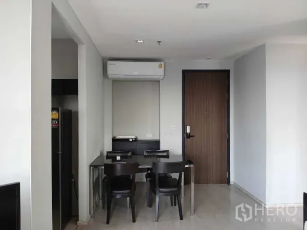 Condominium for rent - Compact dining area for four beside the entry door and wall-mounted air conditioner.