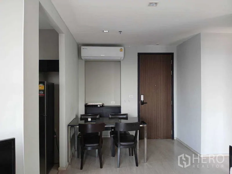 Condominium for rent - Compact dining area for four beside the entry door and wall-mounted air conditioner.