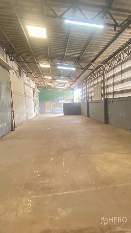 Factory for rent in Bang Sao Thong, Samut Prakan - Reverse view of the long bay showing partitions, lighting, and access to the office.