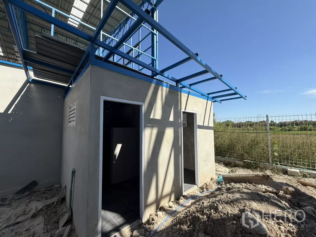 Warehouse for rent in Lam Luk Ka, Pathum Thani - Separate restroom building with two doors and metal canopy next to the fence line.