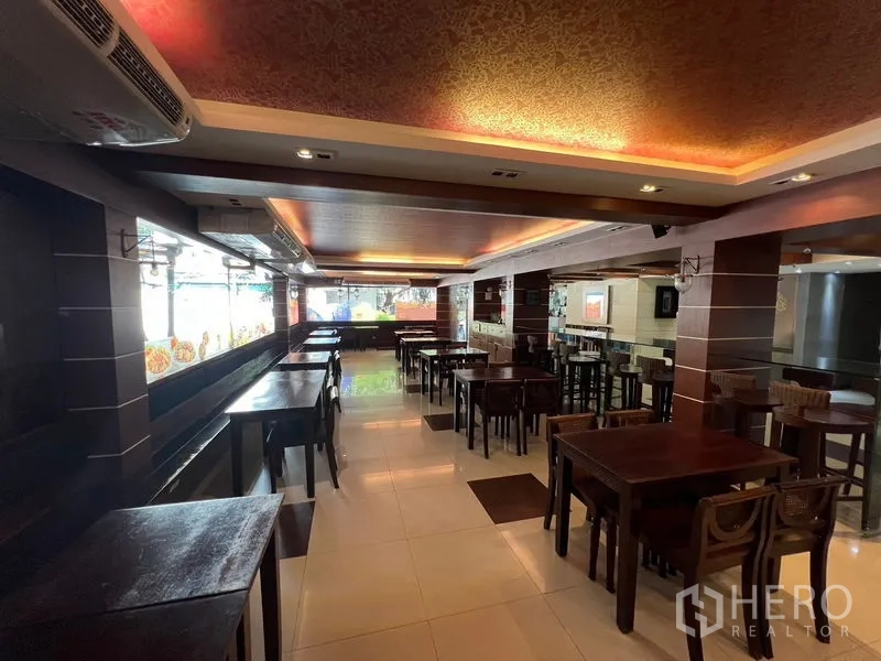 Retail Space for rent or sale in Khlong Toei, Bangkok - Bright dining area with large windows, tables and bar seating suitable for restaurant use.