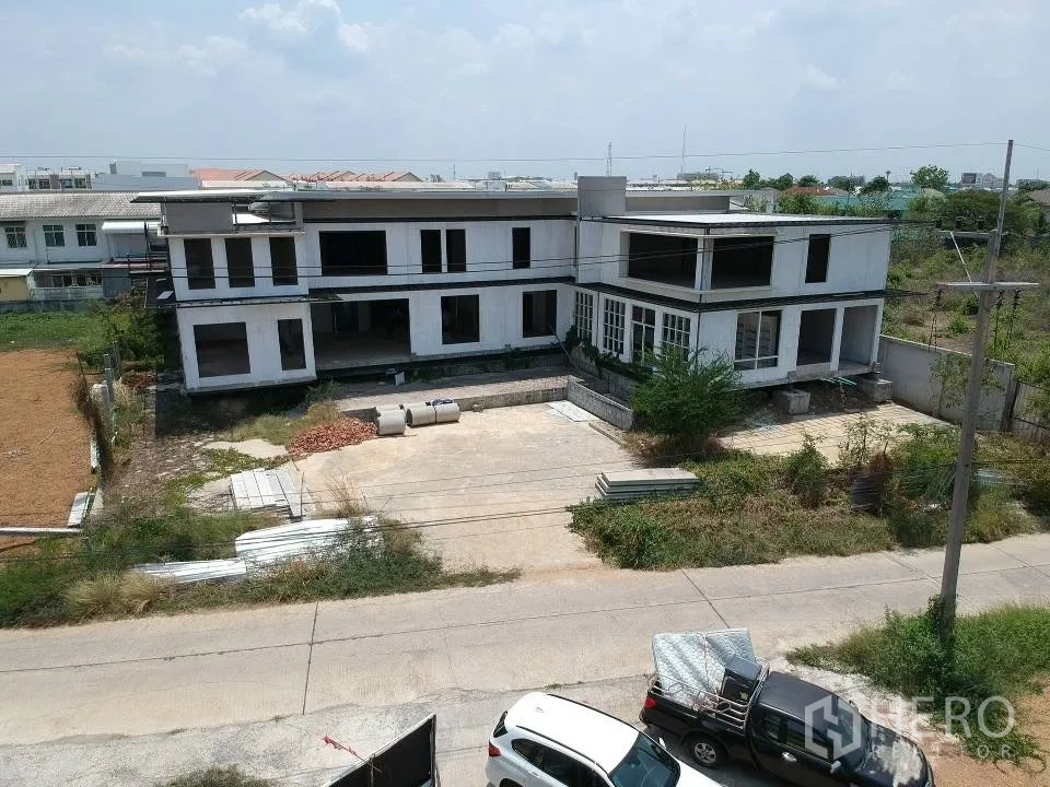Land for sale in Phra Nakhon Si Ayutthaya, Phra Nakhon Si Ayutthaya - Street‑facing facade of the unfinished low‑rise structure with wide concrete forecourt and direct road access.