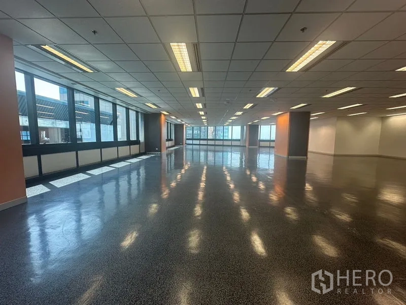 Office Space for rent in Khlong Toei, Bangkok - Open workspace with full-length windows and a distant city outlook.