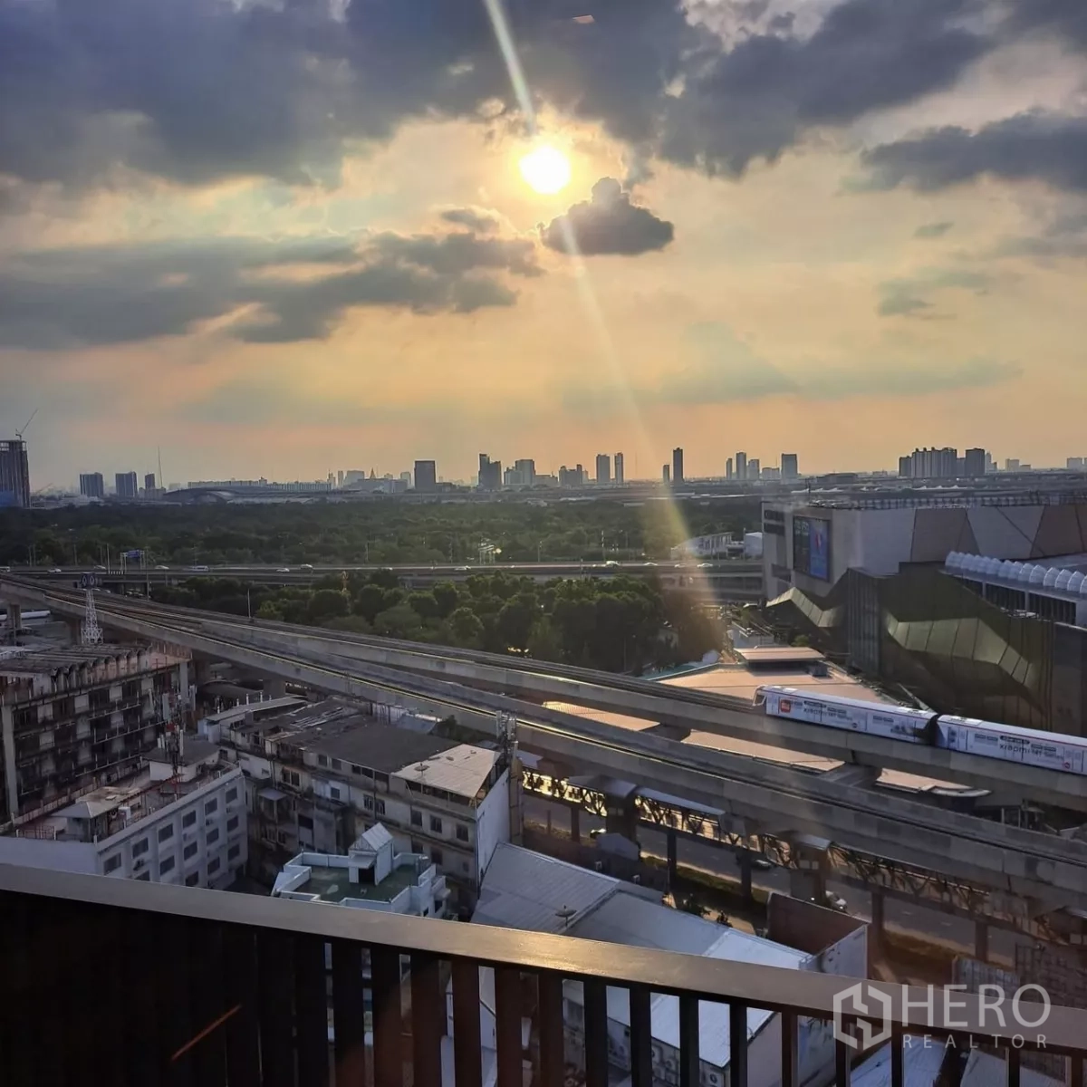 公寓 出租在Chatuchak, Bangkok - 阳台城市景观，夕阳下俯瞰BTS轨道与Central Ladprao。
