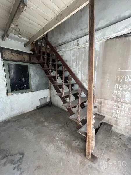 店屋 出租在Khlong Toei, Bangkok - 室内角落，裸露水泥地与木楼梯，有待维修。