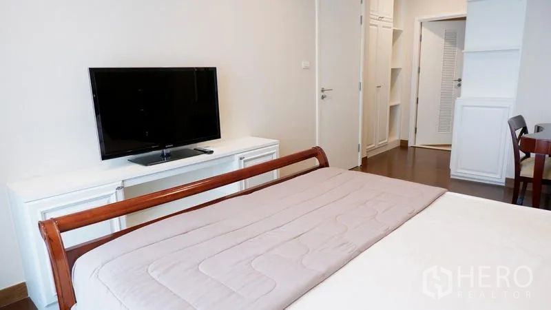 Condominium for rent in Watthana, Bangkok - Bedroom TV console opposite the bed with built-in shelving.