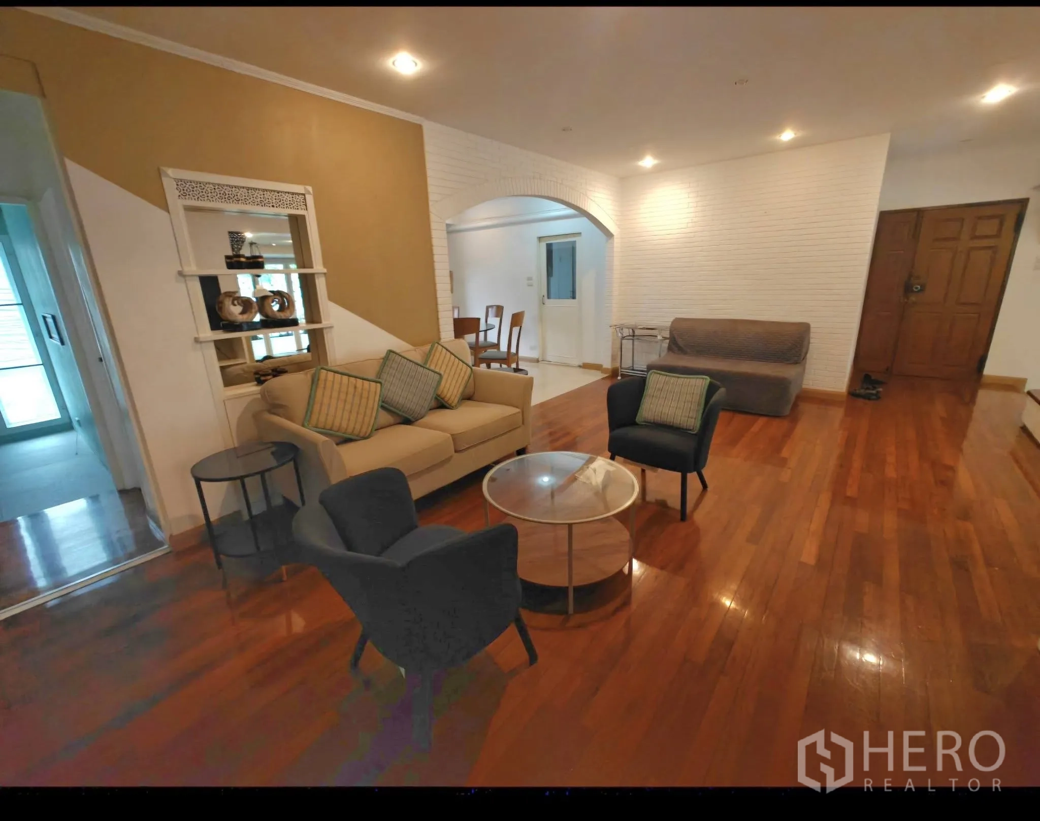 คอนโด for rent in Sathon, Bangkok - พื้นที่นั่งเล่นกว้าง พื้นไม้จริง ชุดโซฟา ไฟดาวน์ไลท์ และผนังซุ้มโค้ง