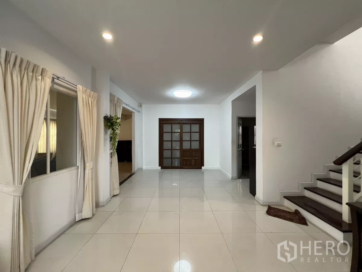 独立式住宅 出租在Bang Kapi, Bangkok - 宽敞门厅，楼梯与木框玻璃门。