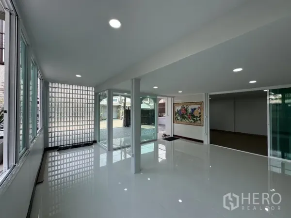 Townhouse for sale in Bueng Kum, Bangkok - Bright ground-floor glass room with floor-to-ceiling windows and glass block wall.