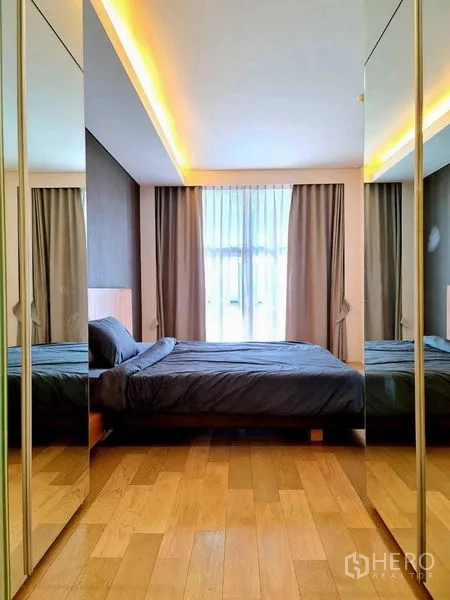 Condominium for rent in Watthana, Bangkok - Cozy bedroom with cove lighting, floor-to-ceiling window and mirrored closets.