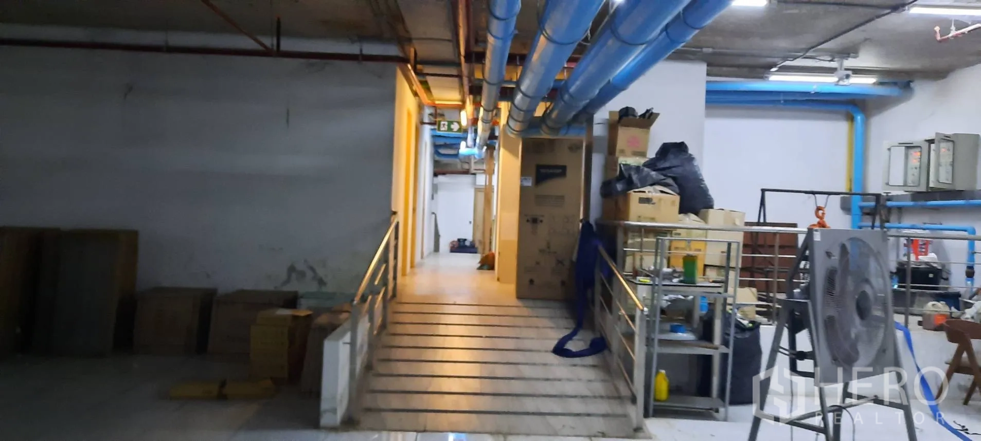 Retail Space for rent in Watthana, Bangkok - Service corridor with ramp access, blue utility pipes, and equipment racks.
