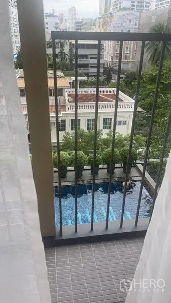 公寓 出售在Watthana, Bangkok - 阳台俯瞰公寓泳池与绿化庭院。