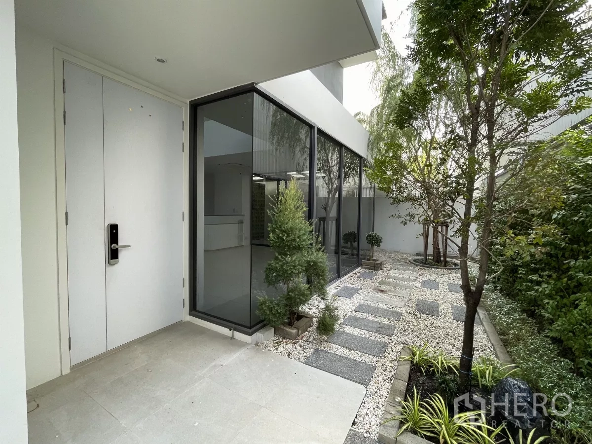 Home Office for rent in Don Mueang, Bangkok - Main entrance with digital lock beside a landscaped courtyard and glass corner.