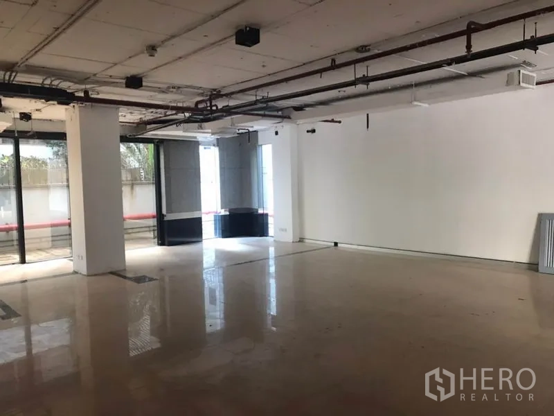 办公空间 出租在Watthana, Bangkok - 宽敞办公室一角，白色墙面，外露管线天花与大面积玻璃