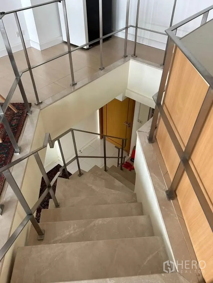 公寓 出租或出售在Yan Nawa, Bangkok - 室内楼梯，金属栏杆连接上下两层。