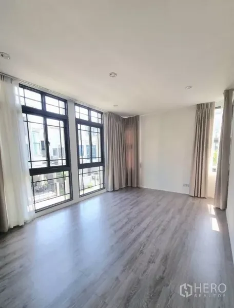 独立式住宅 出售在Prawet, Bangkok - 采光充足的客厅，落地窗与木地板。