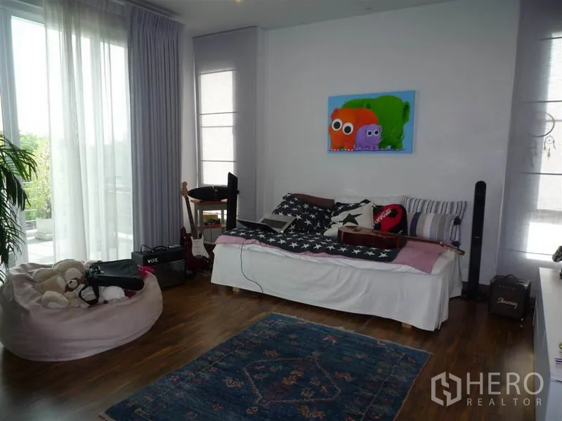 Detached House for rent in Khan Na Yao, Bangkok - Bright secondary bedroom with daybed, large windows and musical equipment