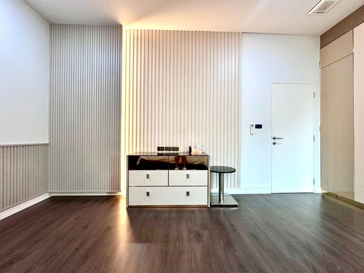 Detached House for rent in Bang Kapi, Bangkok - Minimalist corner with console cabinet, textured feature wall and wood floors.