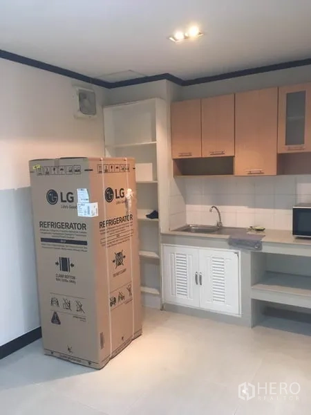 Townhouse for rent in Din Daeng, Bangkok - Fitted kitchen with upper cabinets, sink and a new refrigerator still in its box.