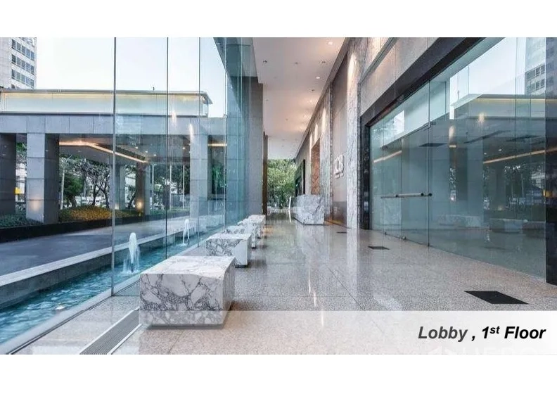 Office Space for rent in Pathum Wan, Bangkok - Modern first-floor lobby with full-height glass walls, marble benches and a decorative water feature.
