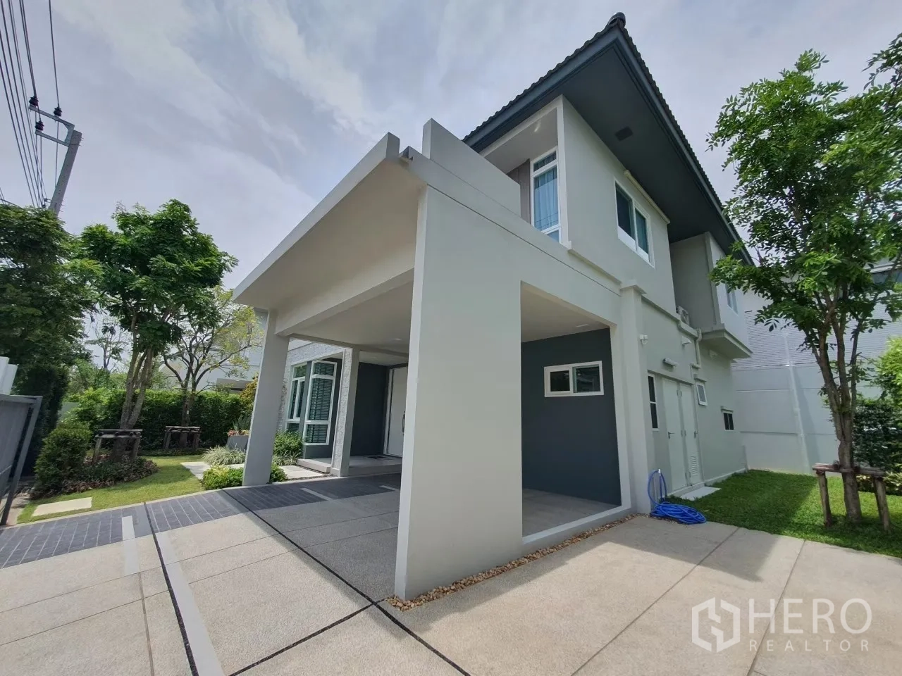 独立式住宅 出租在Prawet, Bangkok - 带顶双车位车棚与房屋侧立面。
