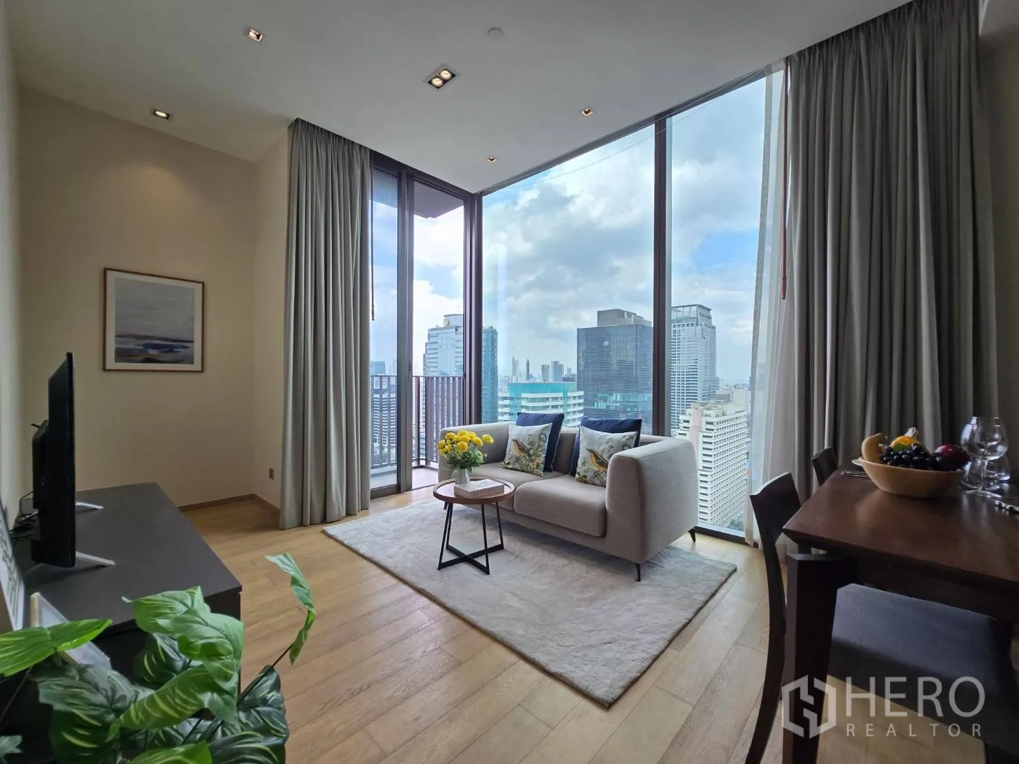 公寓 for rent in Pathum Wan, Bangkok - 客餐厅一体，落地窗观景，配沙发与电视。