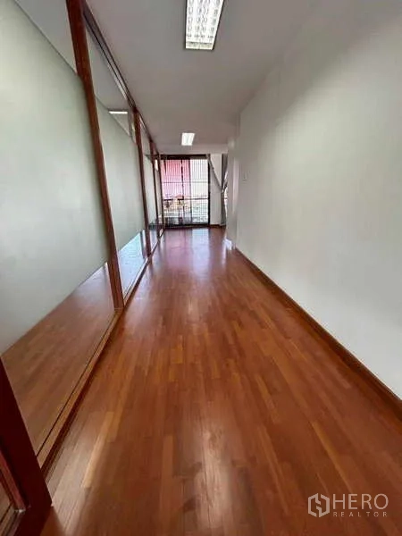 Home Office for rent or sale in Bang Phli, Samut Prakan - Narrow corridor with wood flooring leading to a balcony and frosted glass panels.
