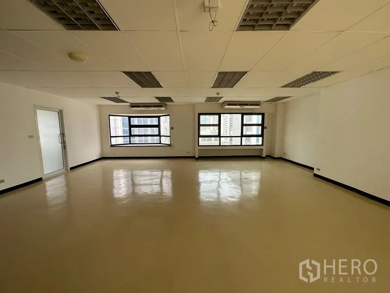 Office Space for rent in Pathum Wan, Bangkok - Open office with wide windows, city views, ceiling air conditioners and grid lighting.