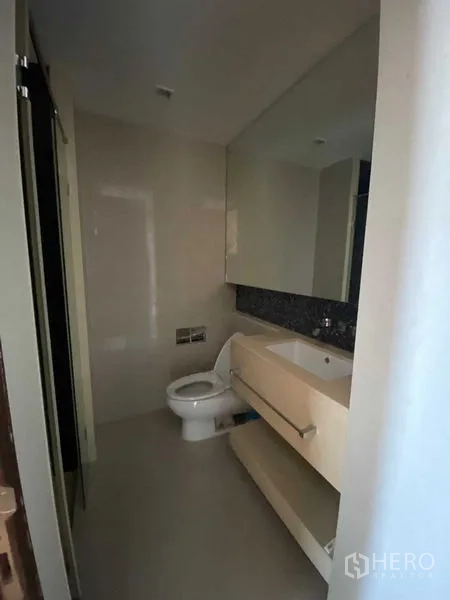 公寓 出售在Ratchathewi, Bangkok - 第二卫浴以中性色调，设大镜与悬空洗手台及坐便器。