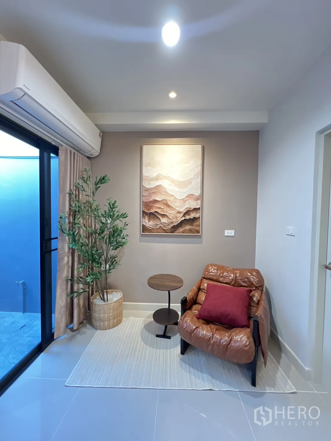 ทาวน์เฮาส์ for rent in Bang Phli, Samut Prakan - มุมอ่านหนังสือพร้อมเก้าอี้อาร์มแชร์ โต๊ะข้าง และต้นไม้กระถางข้างประตูกระจก