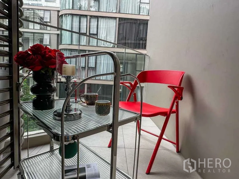 Condominium for rent - Private balcony with red chair and bar cart overlooking the courtyard.