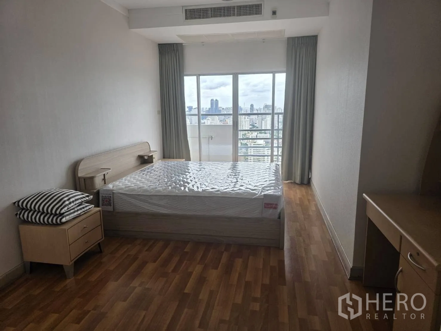 Condominium for rent in Khlong Toei, Bangkok - Third bedroom with queen bed and balcony doors offering city views.