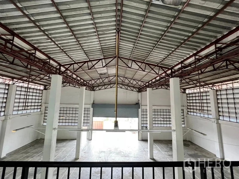 货栈 出租在Min Buri, Bangkok - 仓库内部中央视角，钢结构屋顶与装卸卷门。